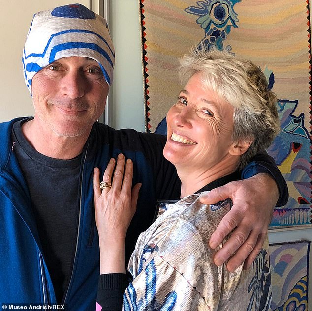 Dame Emma Thompson and her husband smiling together, appearing relaxed and happy in a candid moment.