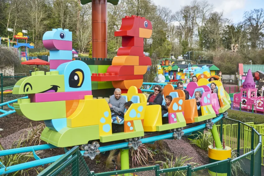 Entrance of Legoland Windsor with giant LEGO models and families arriving.